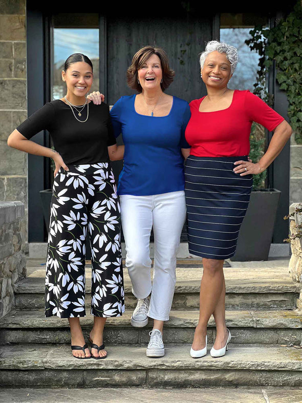 Miik models Meron and Keethai standing next to Miik founder Donna smiling all wearing Miik's Shani reversible half sleeve square neck top. Meron is wearing in the colour black, Donna ink blue and Keethai poppy red 