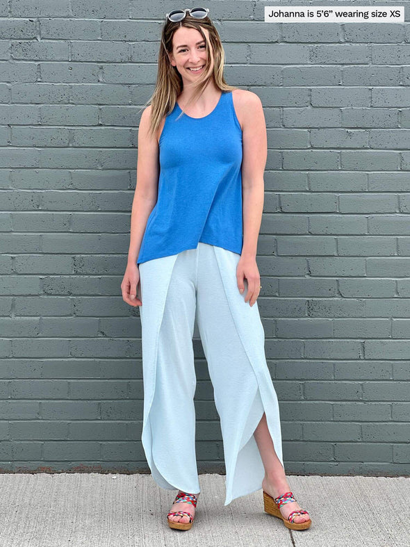 Woman standing in front of a building wearing Miik's Shea tulip pant in light blue with a blue top