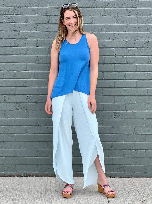 Woman standing in front of a building wearing Miik's Shea tulip pant in light blue with a blue top