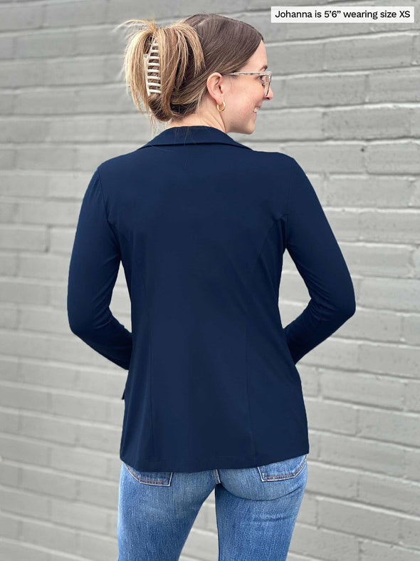 Miik model Johanna (five feet six, size extra small) standing with her back towards the camera showing the back of Miik's Sienna girlfriend blazer in navy