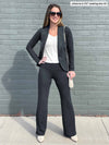 Woman standing in front of a building wearing Miik's Sina straight leg pant in charcoal with a white tank and blazer.