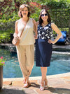 Miik founder Donna and model Yasmine smiling while standing in front of a pool both wearing Miik's Skye ruffle neck blouse. Donna is wearing in the cobblestone print and Yasmine in blossom