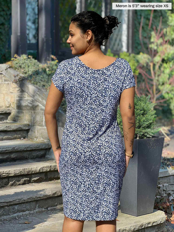 Miik model Meron (5’3”, xsmall) standing with her back towards the camera showing the back of Miik's Sofia reversible everyday dress