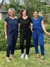 Miik models Keethai and Meron and founder Donna standing next to each other all wearing the same jumpsuit: Miik's Stef v-neck open-back capri in the colours navy, black and ink blue