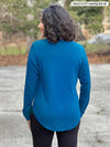 Miik model Meron (5’3”, xsmall) standing with her back towards the camera showing the back of Miik's Susan button up dress shirt