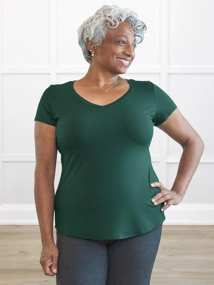 Woman wearing a green t-shirt against a white wall