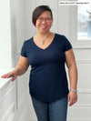 Miik model Mary-Ann (5'0", small) smiling wearing Miik's Sutton v-neck classic tee in navy with jeans