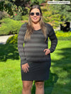 Woman standing on grass wearing Miik's Tray long sleeve striped tee in charcoal stripe with a charcoal skirt