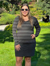 Woman standing on grass wearing Miik's Tray long sleeve striped tee in charcoal stripe with a charcoal skirt