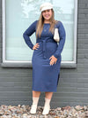 Woman standing in front of a window wearing Miik's Verona long sleeve boat neck dress in navy melange with Blair belt in the same colour