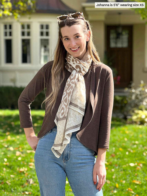 Miik model Jo (5'6", xsmall) wearing Miik's Wesley cropped cardigan in chocolate melange with a tank top in the same colour, a animal print scarf and jeans