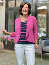Miik founder Donna (5'6, small) smiling wearing Miik's Wesley cropped cardigan in pink with a striped tee with the same colour and navy and white jeans