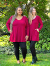 Miik models Sarita and Jo standing next to each other looking away both wearing the same outfit: Miik's Zuri long sleeve pocket tunic in bordeaux and black leggings