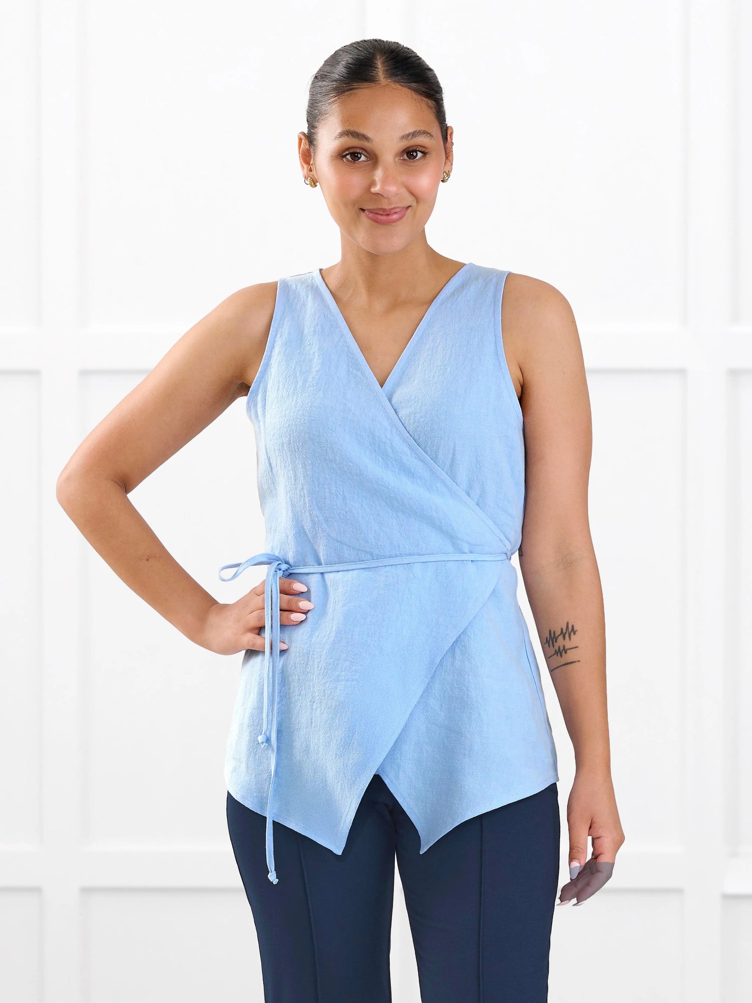 Regina sleeveless linen wrap top for women in Serene blue linen on model Meron, size XS @Meron-XS 