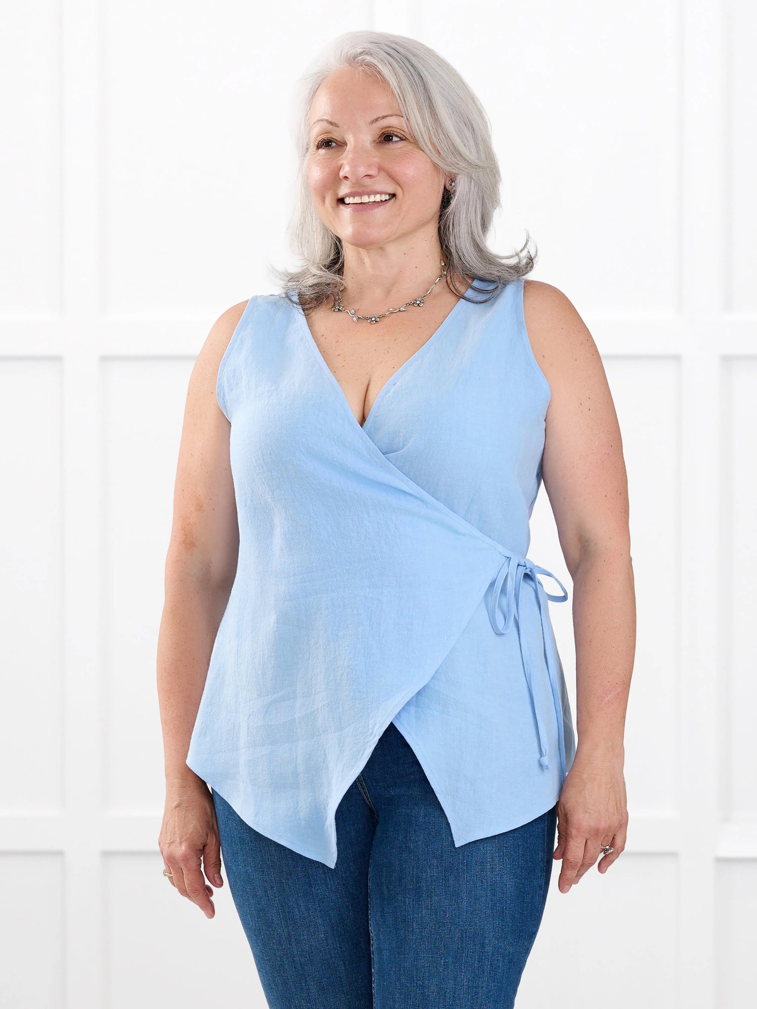 Regina sleeveless linen wrap top for women in Serene blue linen on model Rula, size L @Rula-L 