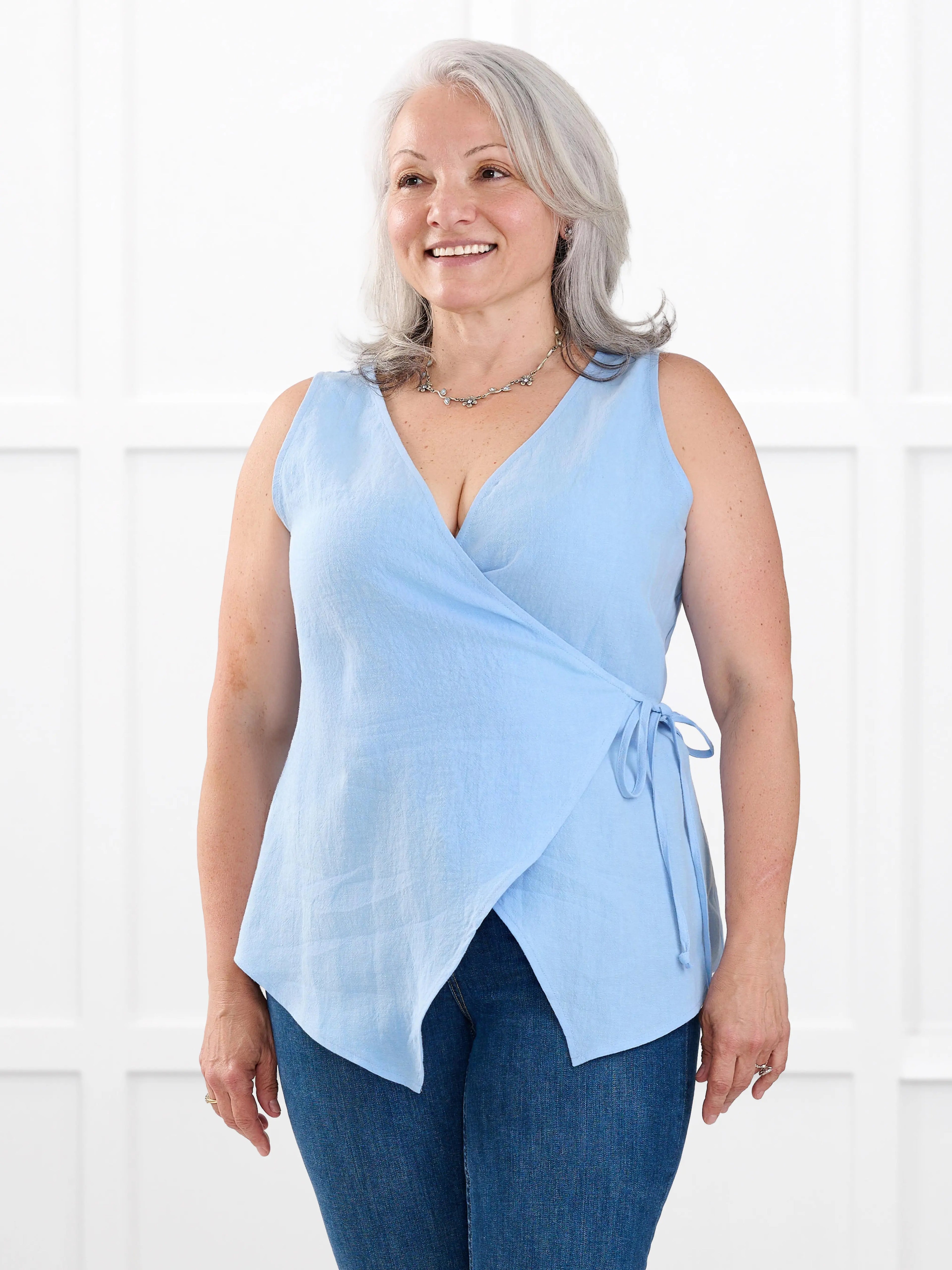Regina sleeveless linen wrap top for women in Serene blue linen on model Rula, size L @Rula-L 