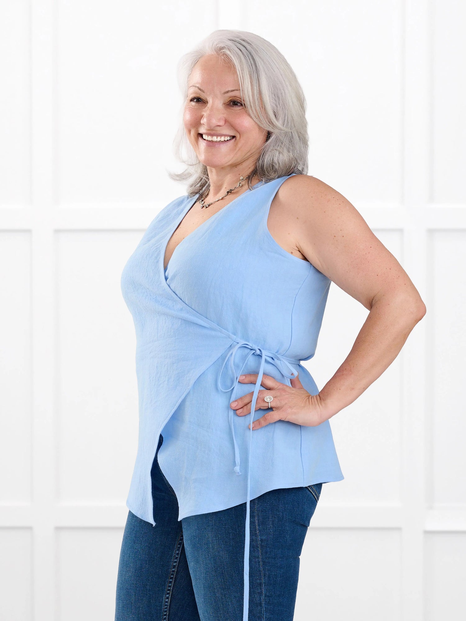 Regina sleeveless linen wrap top for women in Serene blue linen on model Rula, size L @Rula-L 