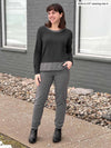 Woman smiling and looking away while wearing Miik's Avalon pill-on dressy pant in granite melange with a long sleeve tee in charcoal/granite 