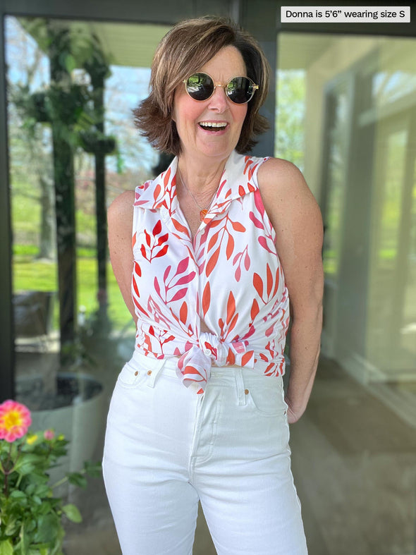 Woman standing outside while wearing Miik's Avy button-up dressy tunic top tied in sunset leaf with white pants