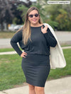 Woman standing in a sidewalk wearing Miik's Bali bat sleeve dress in charcoal with a natural blazer on her shoulders and sunglasses