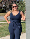 Woman standing next to a wall wearing Miik's Blair bamboo tie waist belt in navy with an all navy outfit.