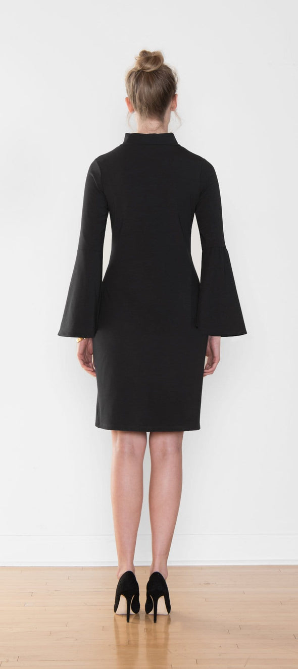 Woman standing with her back towards the camera wearing Miik's Brianne bell sleeve dress in black