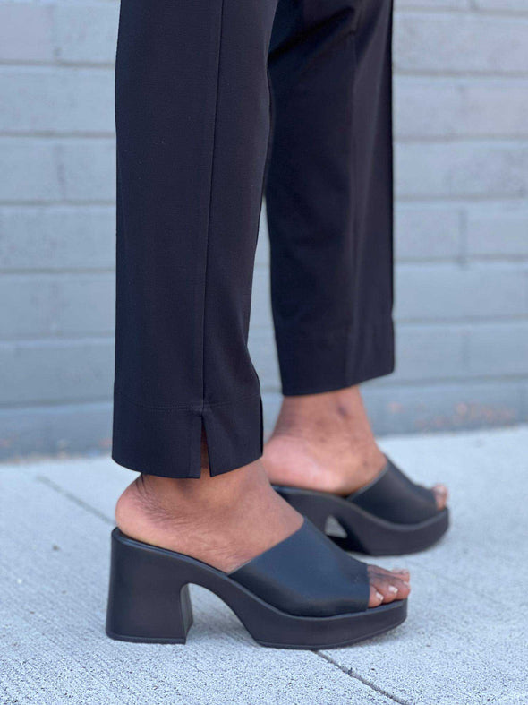 A close-up image of the 2" side slit of Miik's Christal pull-on pintuck dress pant in black.