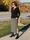 Woman standing in a sidewalk looking away wearing Miik's Devon midi skirt in granite melange with a black long sleeve top and boots