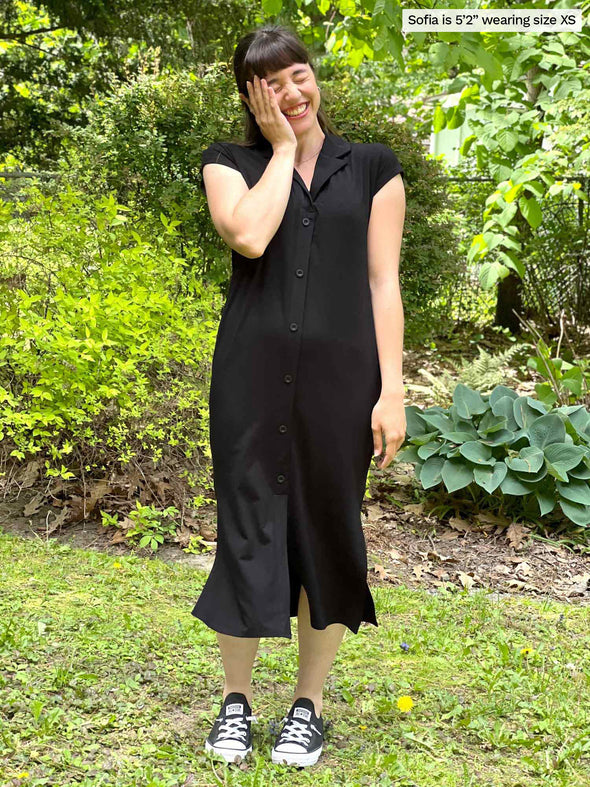 Woman standing in nature laughing and holding her face while wearing Miik's Dylan collared midi sheath dress in black