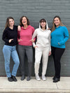 Group of five women all wearing the different colours of Miik's Essex cropped fleece hoodie: black, pink pomegranate, oatmeal and teal melange 