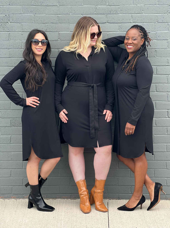 Three women standing in front of s brick wall wearing Miik's Finian collared shirt dress in black