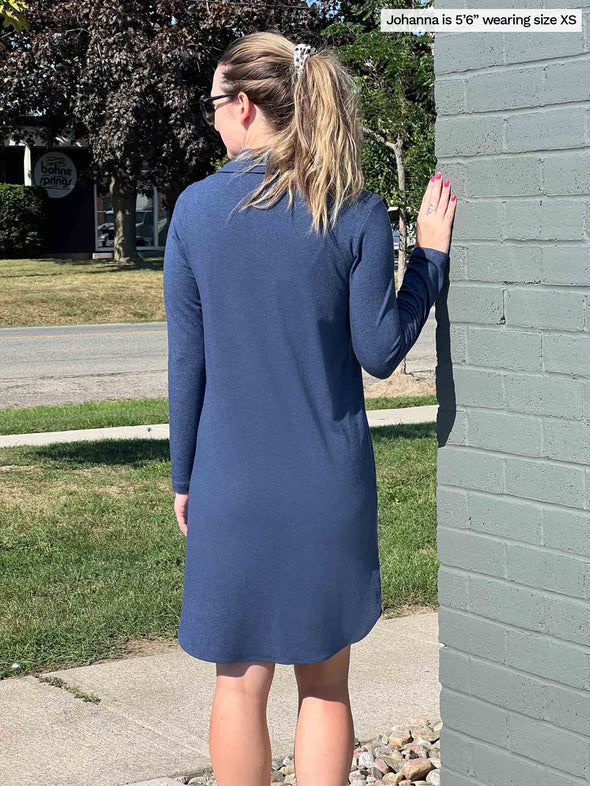 Woman standing with her back towards the camera showing the back of Miik's Finian shirt collar long sleeve dress in navy melange