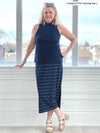 Miik model Carolyn (five feet ten, size large) smiling wearing Miik's Frankie midi skirt in navy wide pinstripe with a mock neck tank in navy and beige sandals 