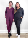 Two women standing side by side both wearing Miik's Fraya stretchy lounge jumpsuit in port melange and charcoal