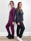 Two women standing against each other wearing Miik's Fraya stretchy lounge jumpsuit in port melange and charcoal