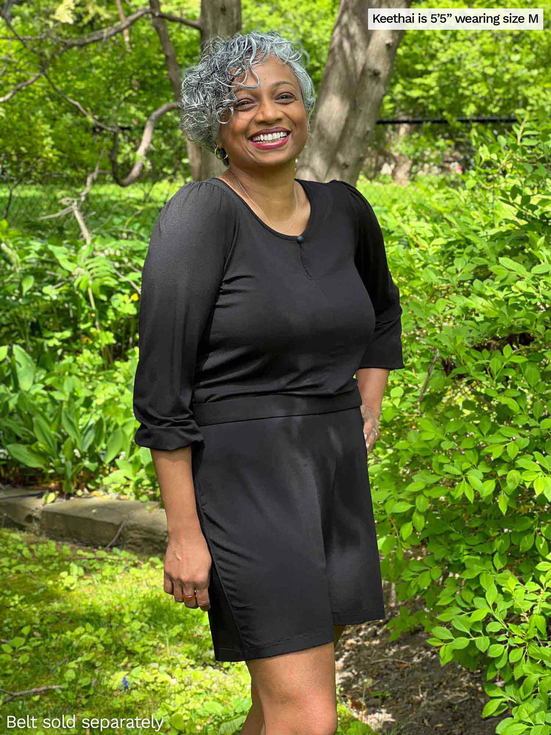 Woman standing in nature smiling and wearing Miik&