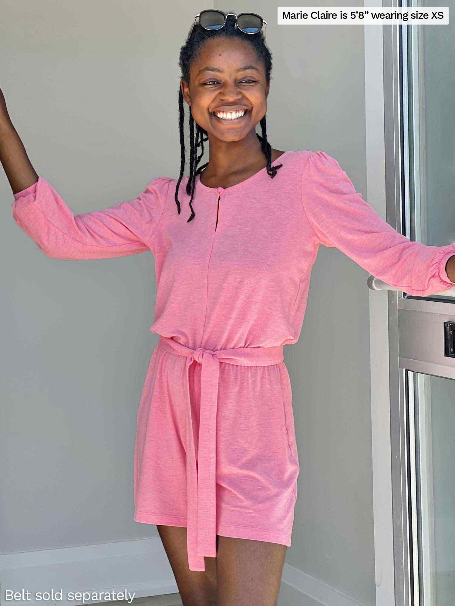 Woman standing in front of a wall smiling wearing Miik&