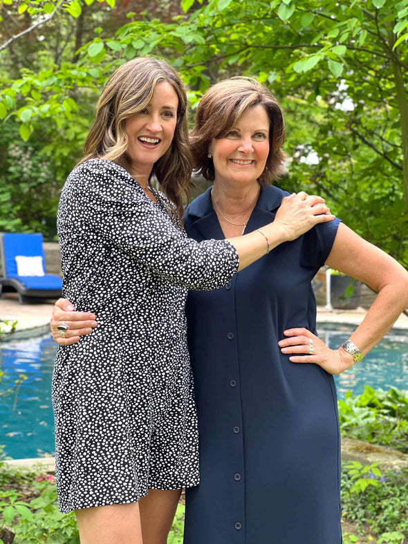 Two women standing in front of a pool wearing Miik's Janice 3/4 sleeve short romper in blackn and white, along with Dylan collared midi sheath dress in navy colour.