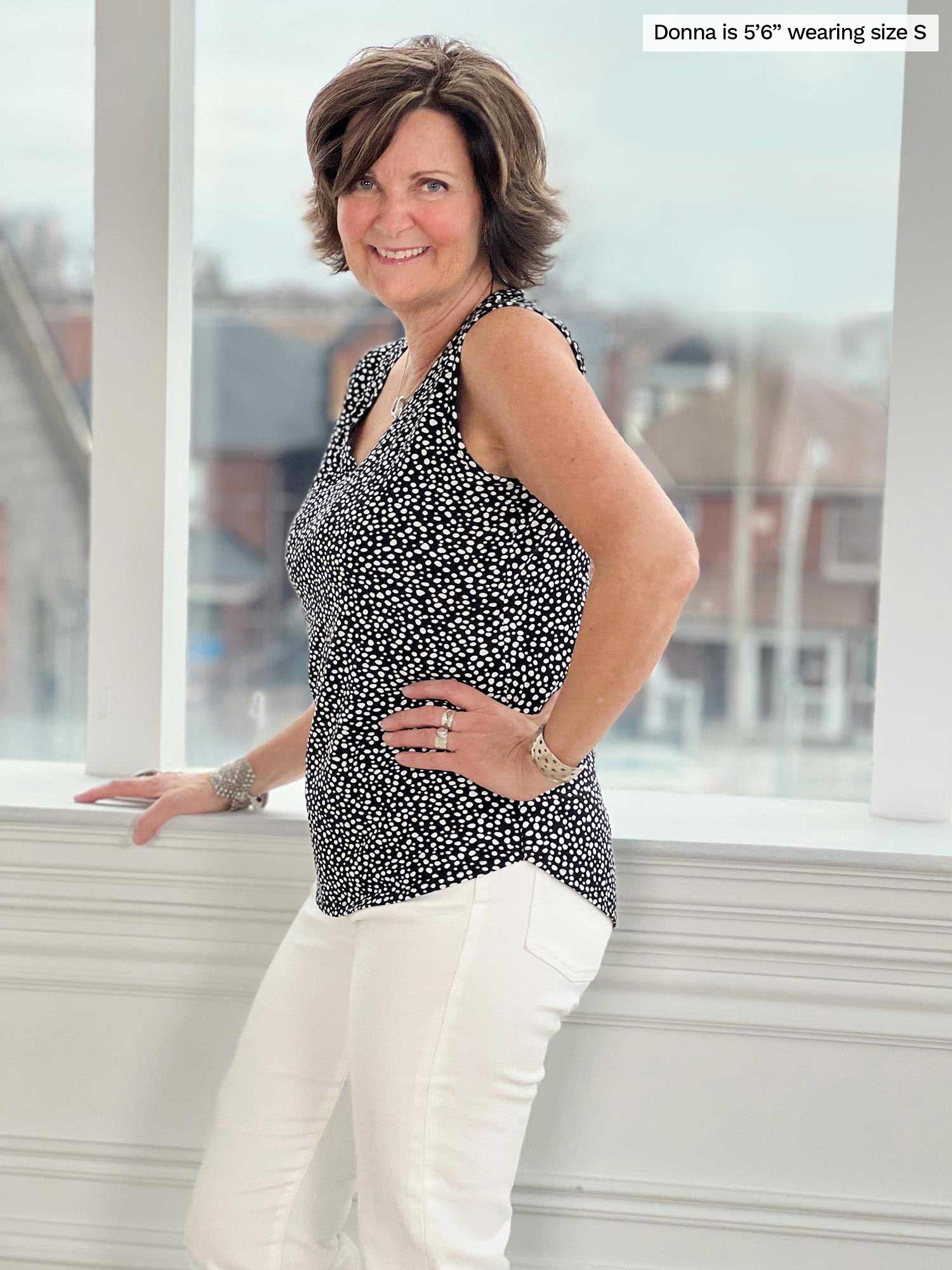 Woman smiling standing sideway in front of a window wearing Miik&