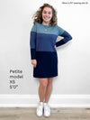 Woman standing in front of a white wall wearing Miik's Kennedy colourblock tunic in fog melange/navy melange/navy as a dress with white sneakers 