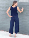 Miik model Johanna (five feet six, size extra small) standing with her back towards the camera showing the back of Miik's Kimmay open-back capri jumpsuit