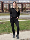 Woman standing in a sidewalk wearing an all black fleece outfit: Miik's Linaya luxe fleece jogger and a cropped hoodie