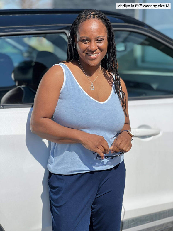 Woman smiling leaning against to a car wearing a navy pant with Miik's Lori reversible slouchy tank top in denim melange 