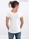 Woman standing in front of a wall with her back towards the camera wearing Miik's Marianna reversible classic tee in white with jeans.