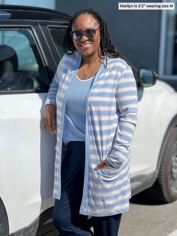 Woman standing next to a car wearing Miik's Melanie classic cardigan with pockets in denim peony stripe, denim melange top and navy pants