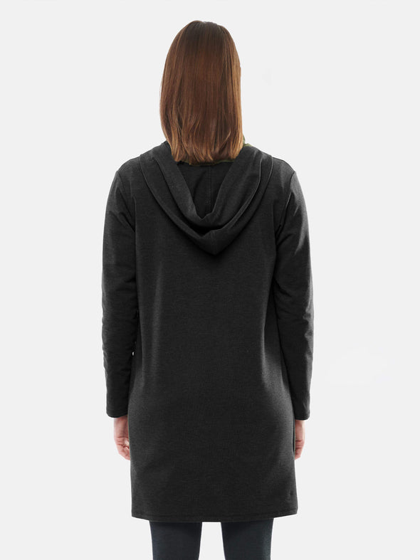 Woman standing with her back towards the camera wearing Miik's Paulina pocket hooded cardi in black.