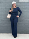 Woman smiling in front of a brick wall wearing Miik's Reed high waisted wide leg pant in navy with a matching colour long sleeve top