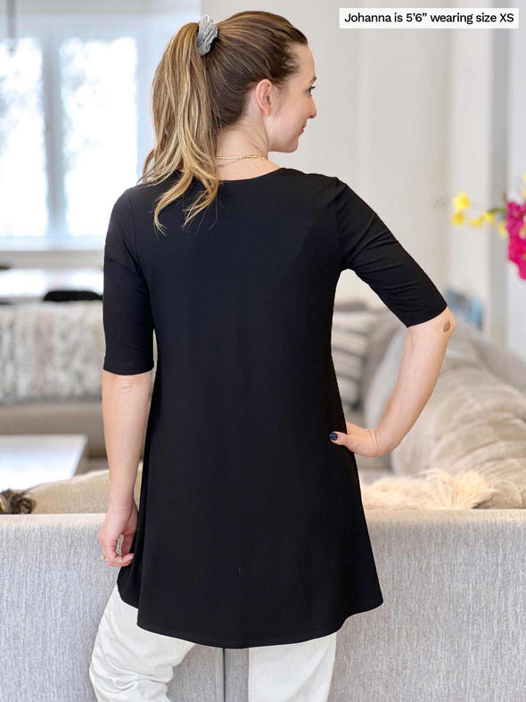 Woman standing with her back towards the camera showing the back of Miik's Rocelle half-sleeve scoop neck tunic 