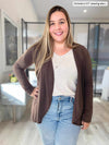 Woman standing in a office room wearing Miik's Rory waterfall cardigan in chocolate melange along with a oatmeal v neck top and jeans  