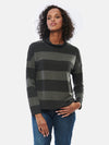 Woman standing in front of a white wall wearing Miik's Scarlett mock neck sweater in dark ash stripe and jeans